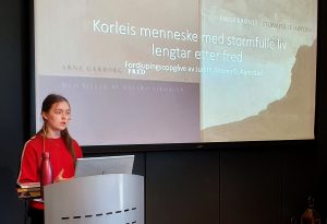 jente holder tale på scene