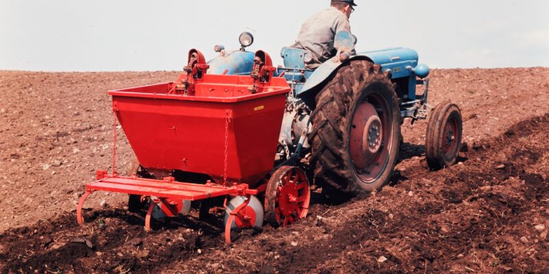 Potetsetter frå Underhaugs Fabrikk AS bak Fordson-Dexta-traktor i arbeid. Foto: Ukjent fotograf / Jærmuseet.