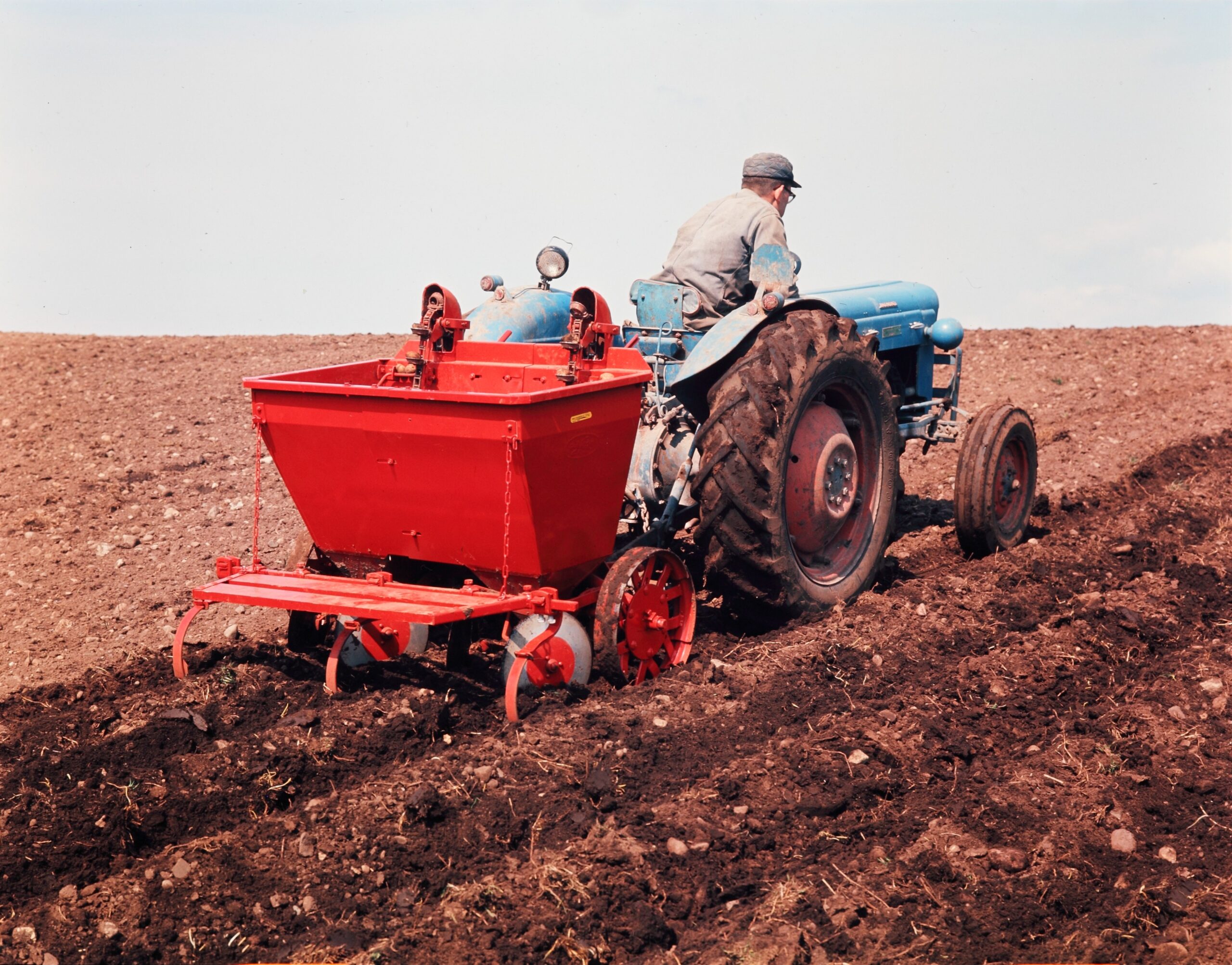 Potetsetter frå Underhaugs Fabrikk AS bak Fordson-Dexta-traktor i arbeid. Foto: Ukjent fotograf / Jærmuseet.
